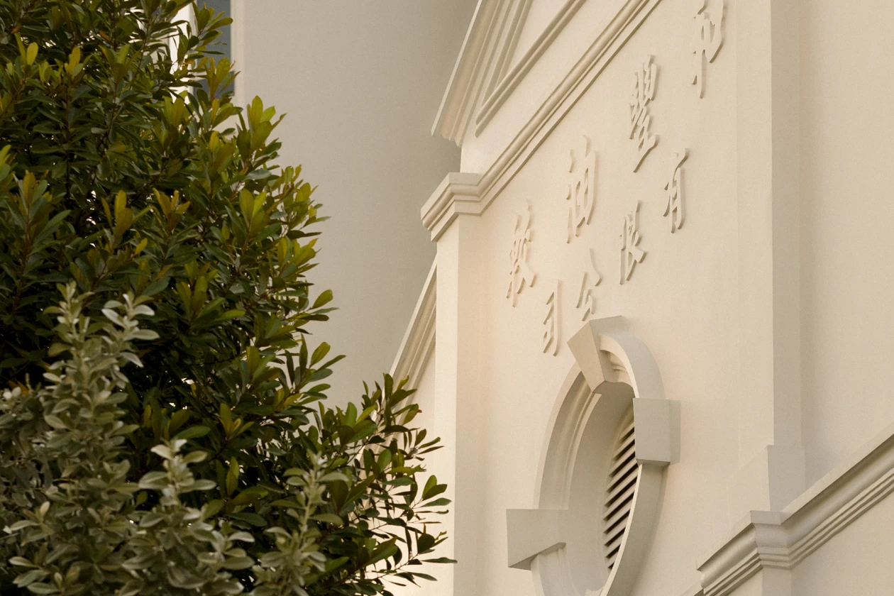 home-story-heritage-1-1 upper half shot of a white building next to a tree