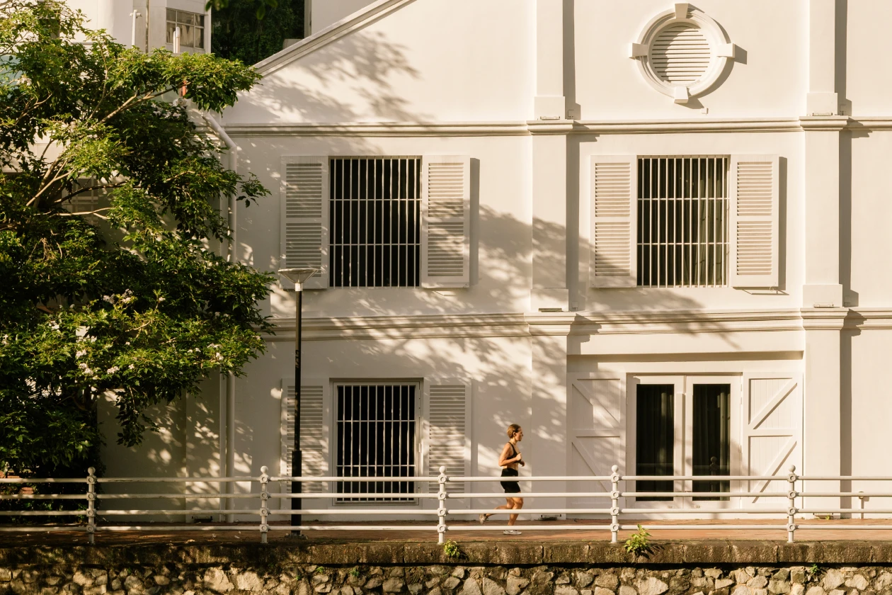 large white building by the promenade with a woman jogging in front of it