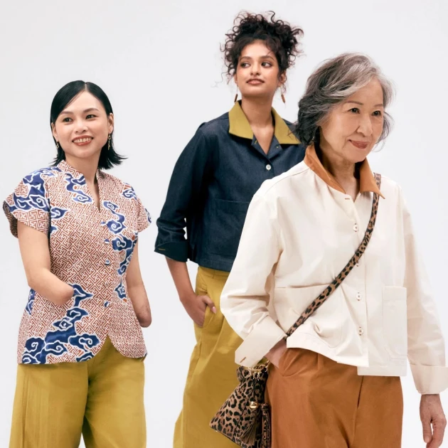 three stylish women walking while smiling to the side