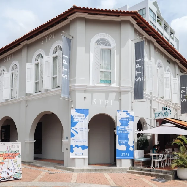grey colonial-style building with a signboard showing "stpi"