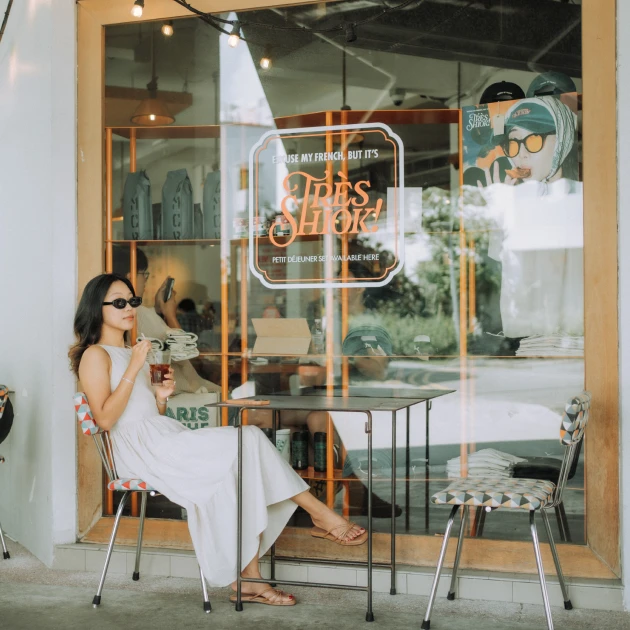 a woman enjoying tea while sitting outside of a cafe