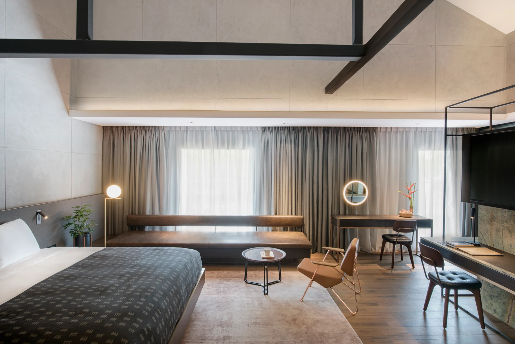 room-rvs-carousel-1-1 industrial style hotel bedroom with king-sized bed and large sofa