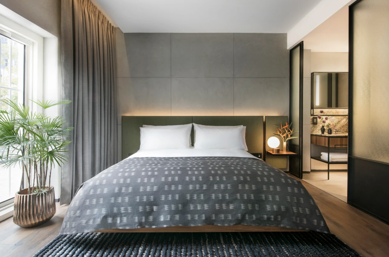 roomssuites-index-room-1 blue and grey themed hotel bedroom with en suite