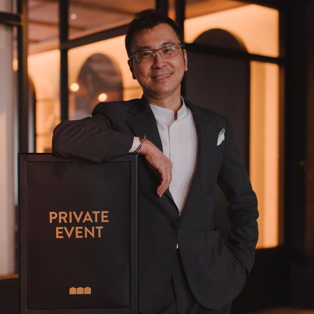 485647818_1202654705195549_3738270661362502024_n man in business suit leaning against a signboard showing "private event"
