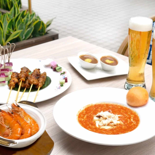 a variety of dishes and beer on a wooden table