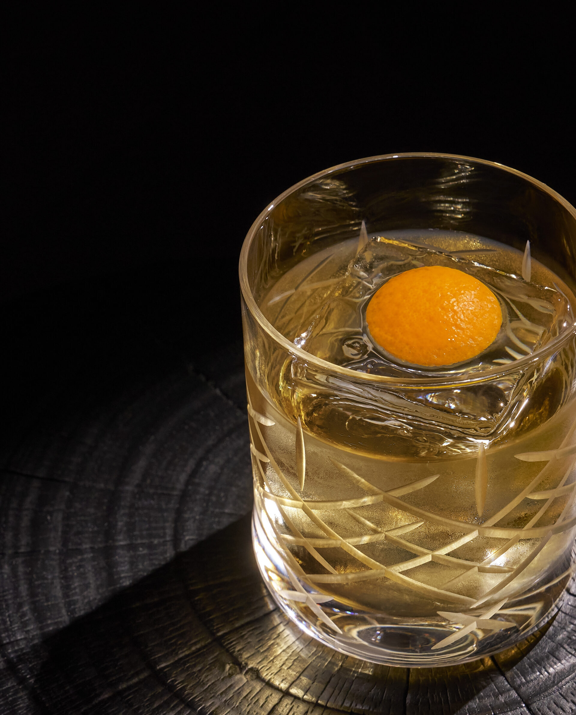 drink in a glass with an orange peel inside