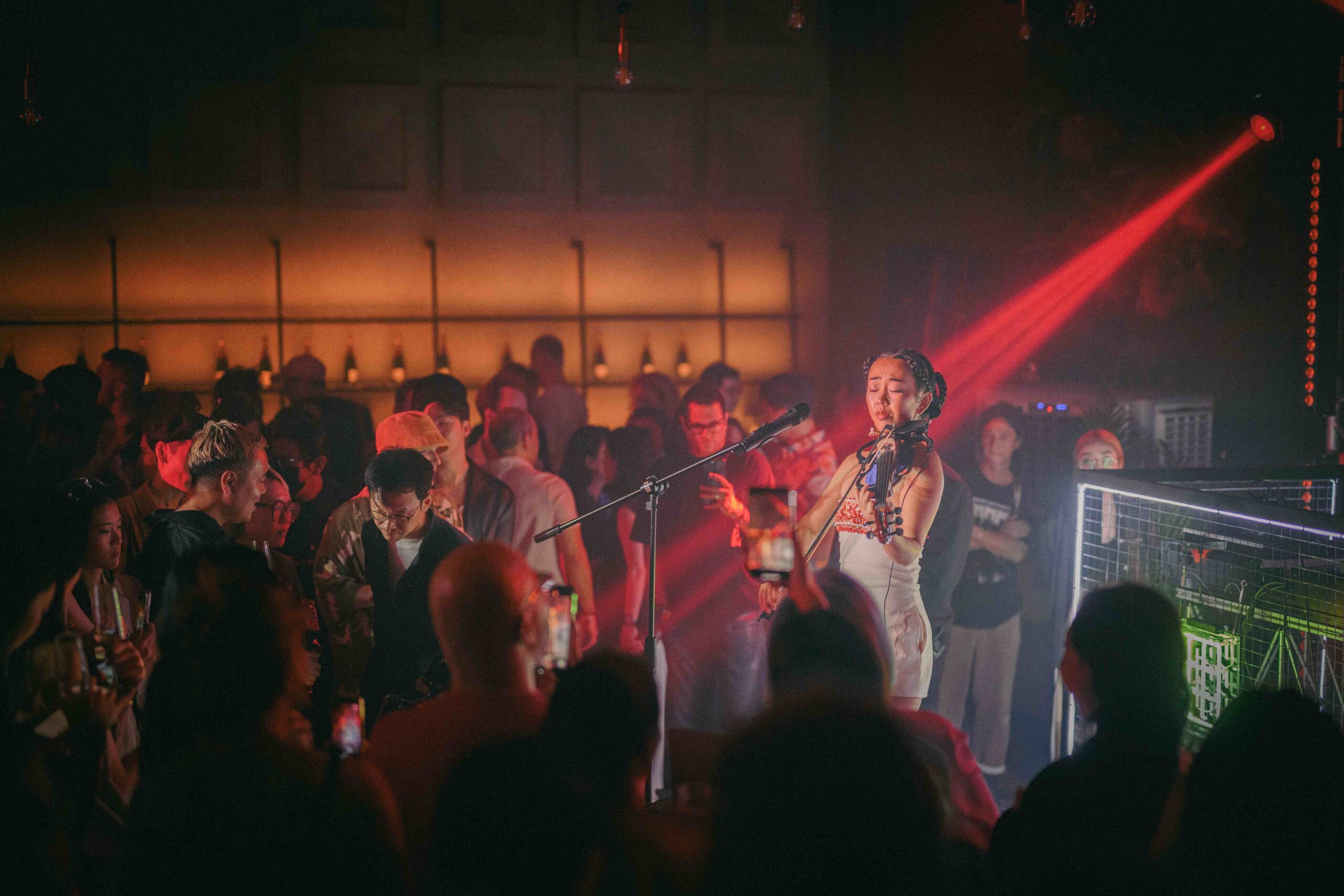 female violinist playing a violin in a crowded hall