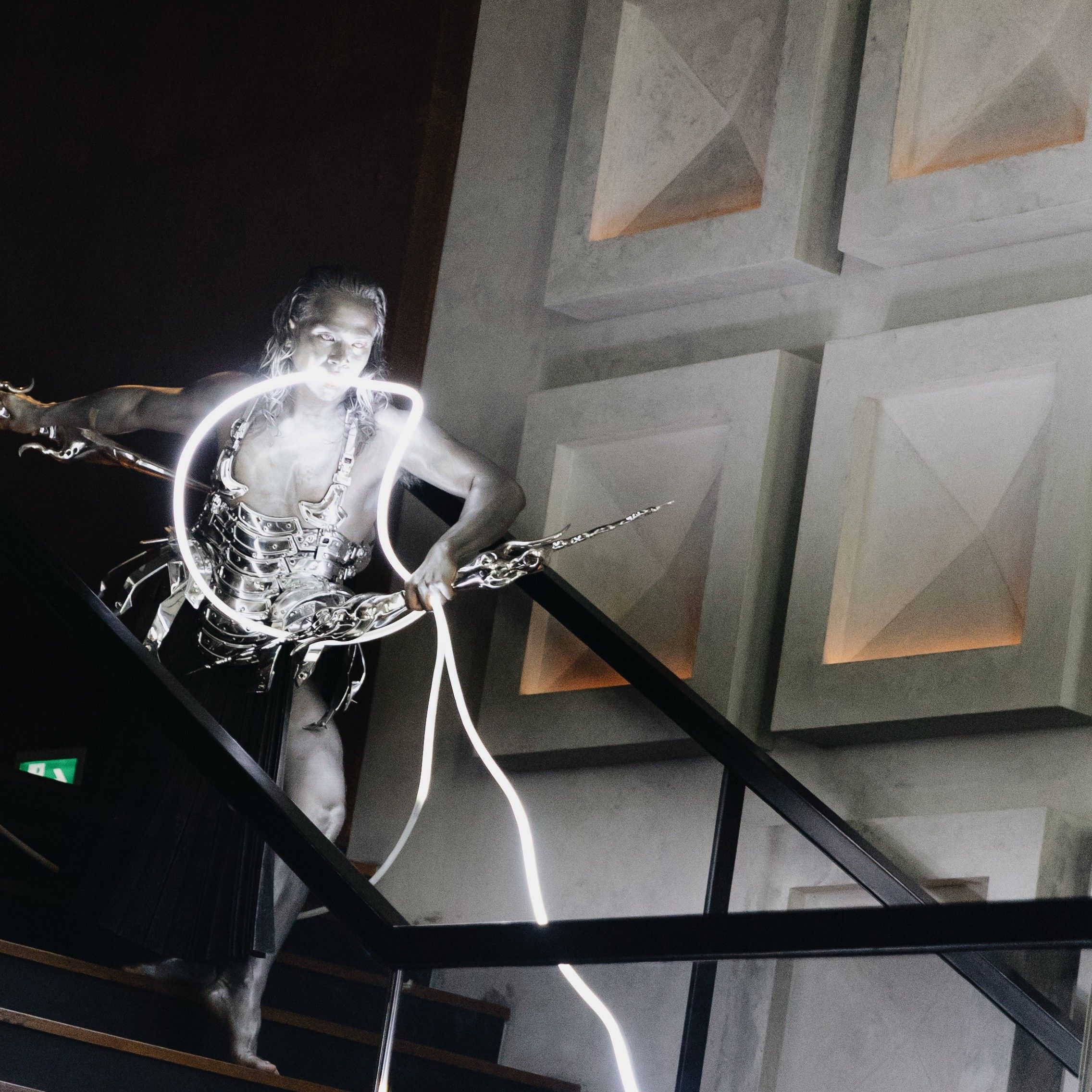a man performing in a silver armour while going down the stairs
